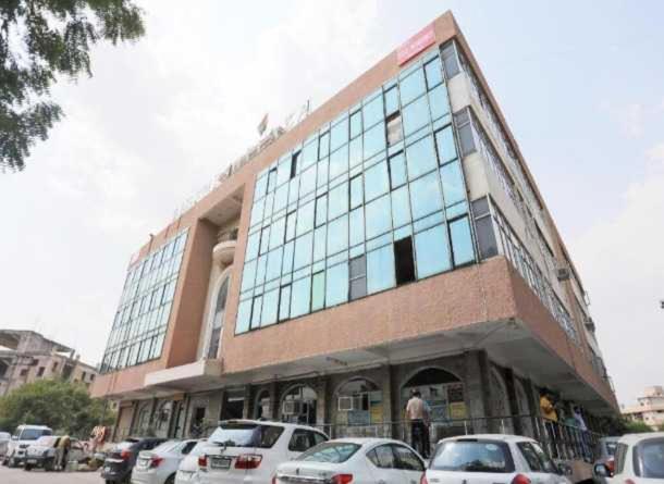 ein großes Gebäude, vor dem Autos parken in der Unterkunft Hotel O DSG Residency in Faridabad