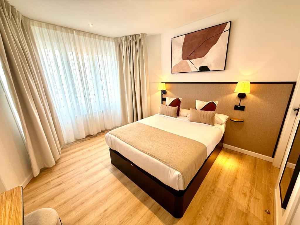 a hotel room with a bed and a large window at Mucho Madrid in Madrid