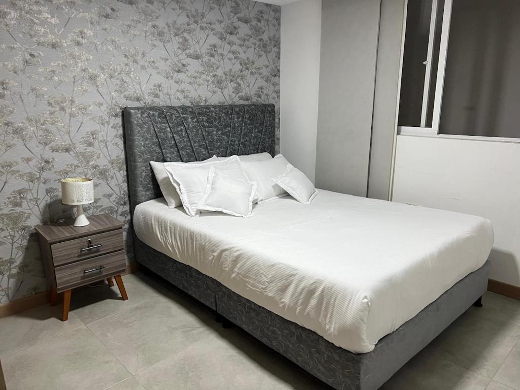 a bedroom with a bed and a nightstand with a bed sidx sidx sidx sidx at Spa house with private Jacuzzi in Dosquebradas - Pereira in Dosquebradas