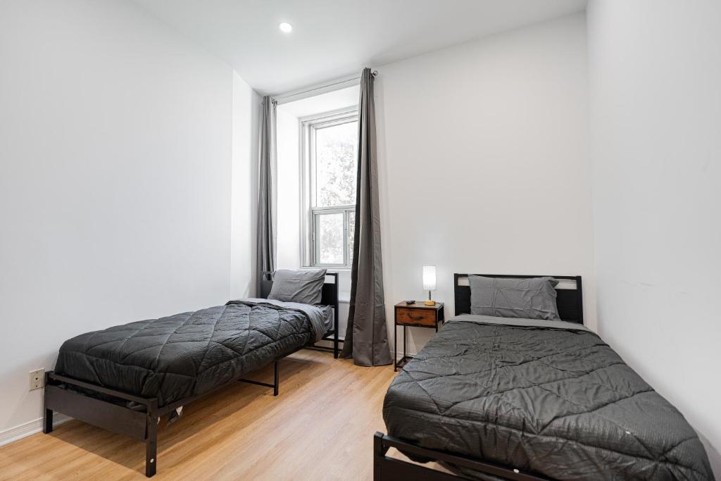 une chambre avec deux lits et une fenêtre dans l'établissement Loft Studio & 2 Single Beds For 2 Guests with Parking, à Montréal