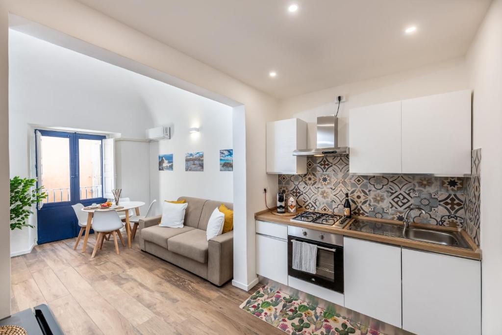 una cucina e un soggiorno con un divano e un tavolo di Terrazza in Centro - Casa Torres ad Acireale