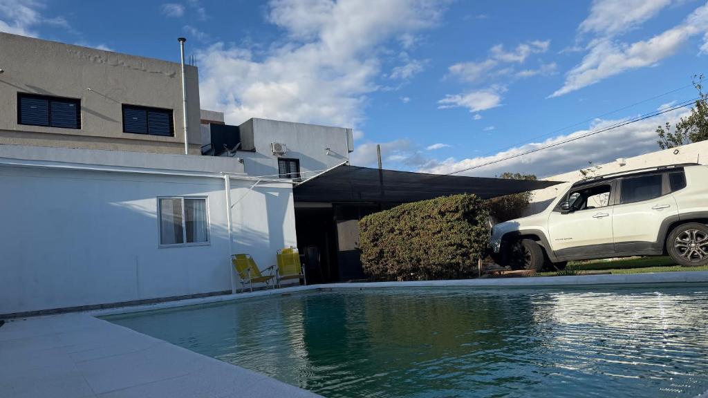 a white truck parked next to a house with a swimming pool at brisas del dique in San Fernando del Valle de Catamarca