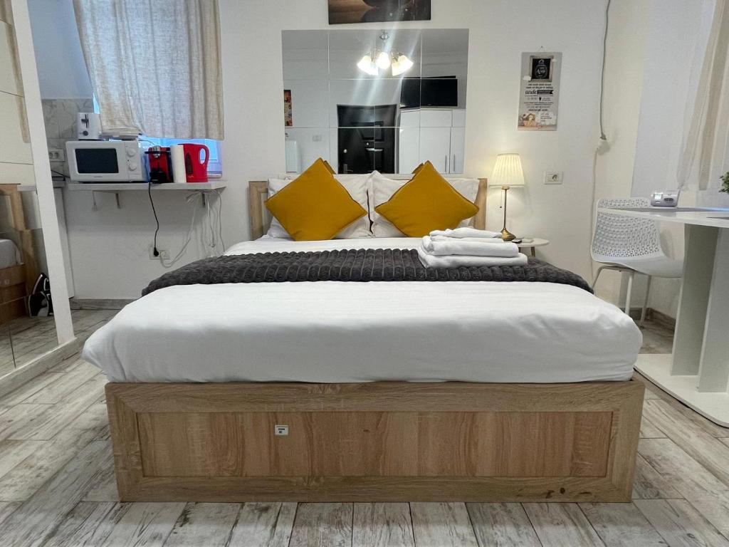 Old Town House في بوخارست: غرفة نوم بسرير كبير مع مخدات صفراء