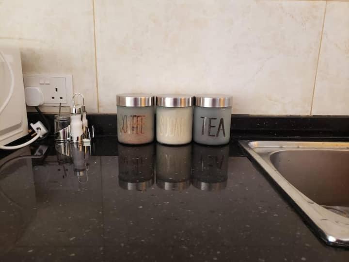 three cups sitting on top of a kitchen counter at Budget apartments near American embassy in Lusaka