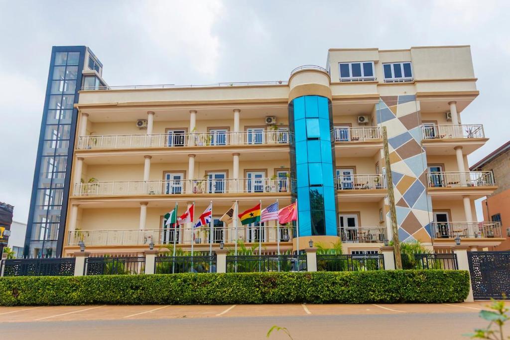 a building with flags in front of it at Sasselo Hotel in Accra