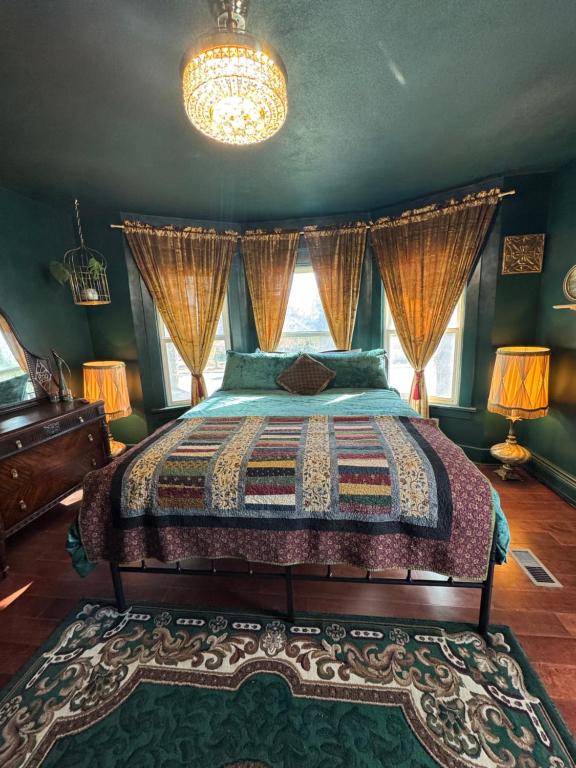 een slaapkamer met een bed en een kroonluchter bij The Suite in Fort Morgan