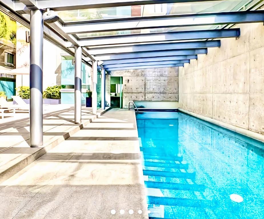 una piscina coperta con acqua blu in un edificio di Polanco condo, alberca y Gym a Città del Messico