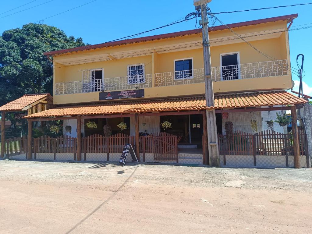 un edificio giallo con una recinzione di fronte di Maria do Bairro a Guaraciaba do Norte