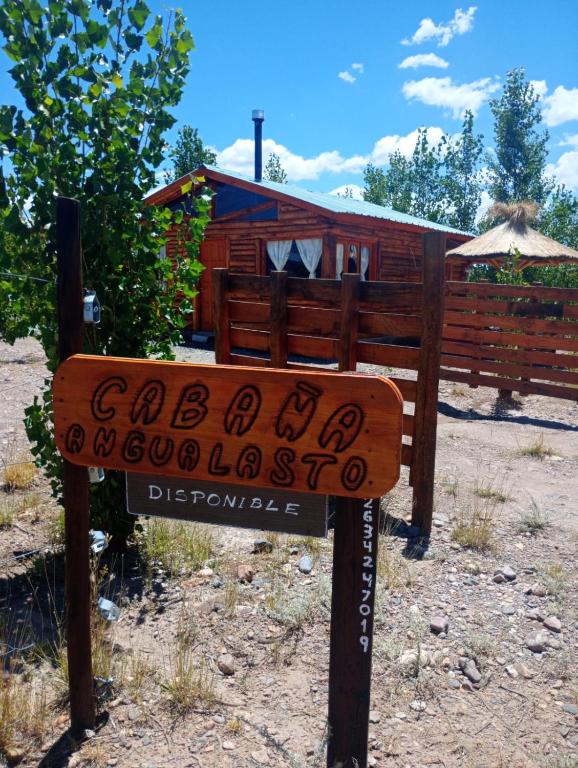 a sign in front of a wooden house at Cabañas Angualasto in Uspallata