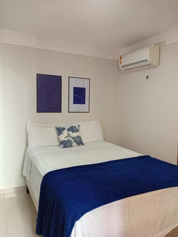 una camera bianca con un grande letto con lenzuola blu di Apartamento na praia de Manaíra João Pessoa PB a João Pessoa