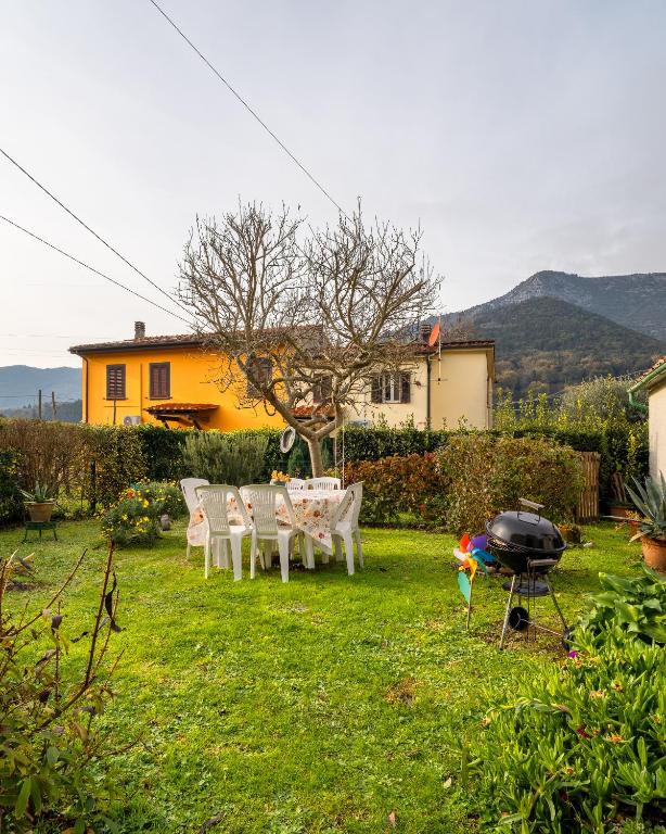 a backyard with a table and chairs and a grill at I Cuculi vacation home in Lucca in Lucca
