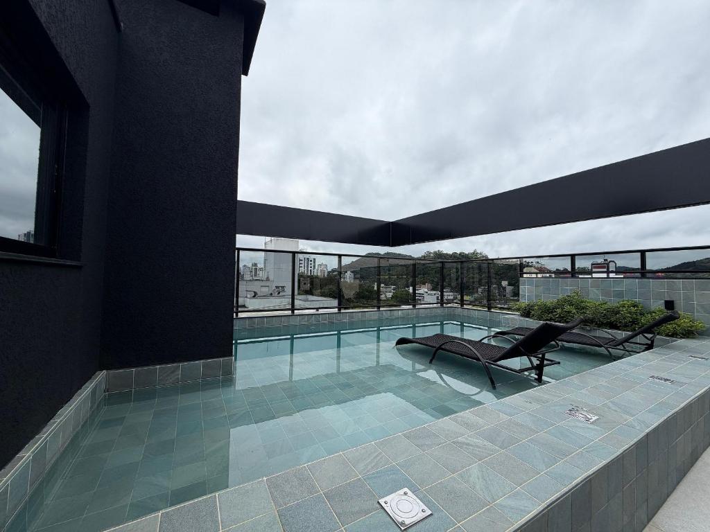 a swimming pool on top of a building at Estúdios Modernos e Completos em Blumenau - ELN in Blumenau