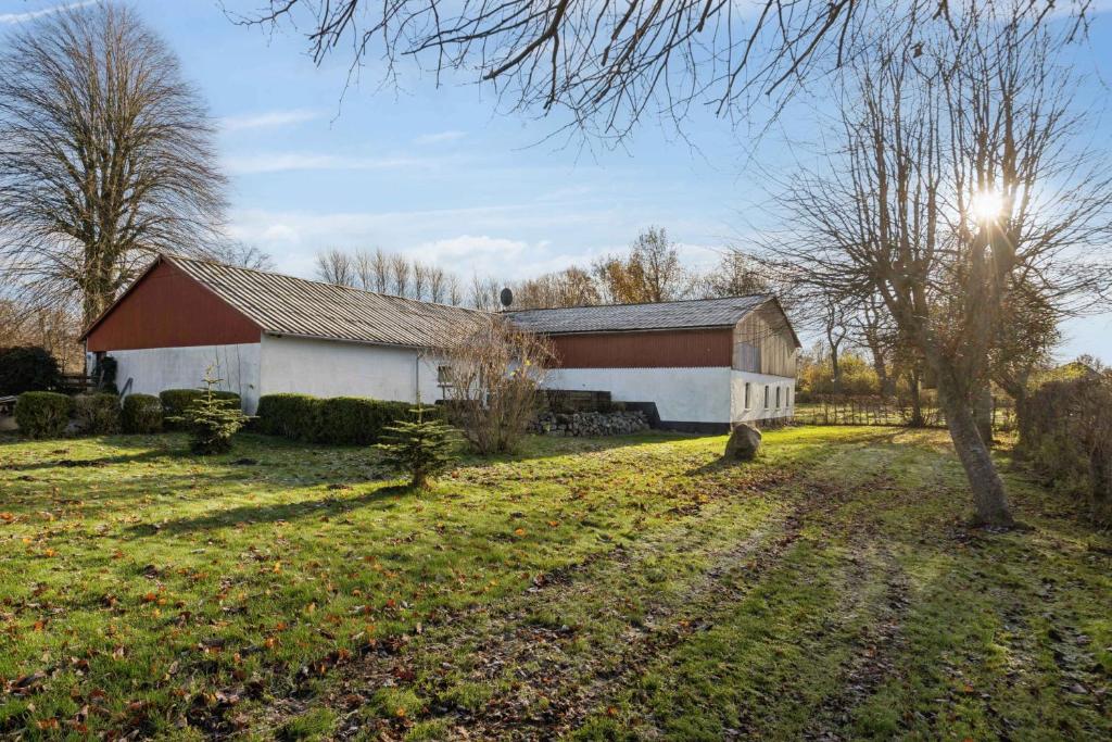 a barn in a field with the sun behind it at Calm Holiday Home With Great Outings in Kollund