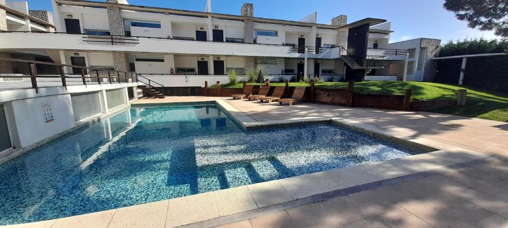 a swimming pool in front of a building at Apartmento, Punta 30 Complejo in Mar Azul