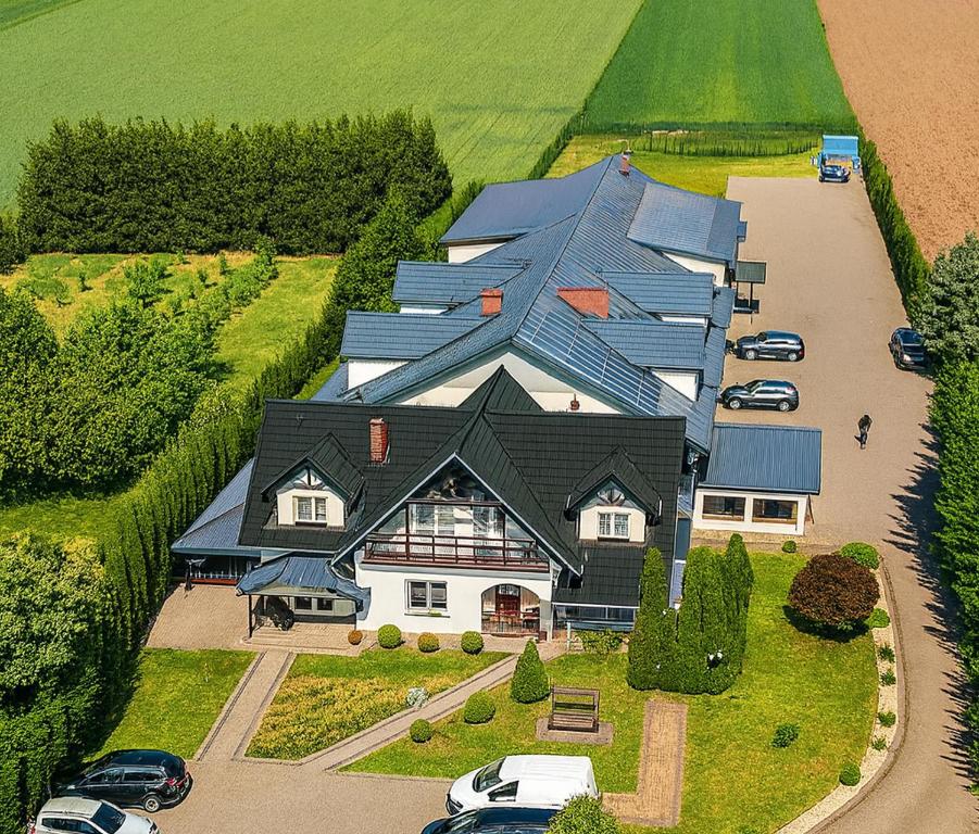 a large house with cars parked in a driveway at Motel Domowy Gościniec in Łomża