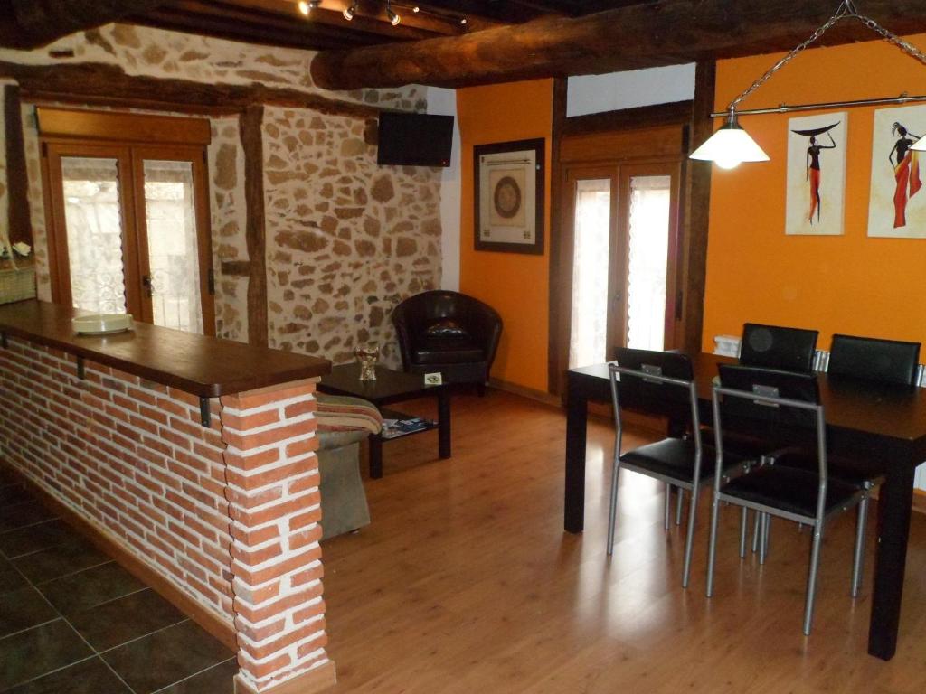 a living room with a table and chairs and a fireplace at Alborada in Sequeros