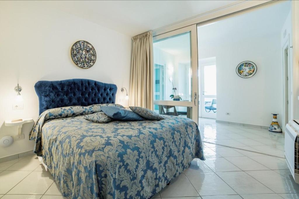 a bedroom with a bed with a blue bedspread at La Dolce Vita Ravello - Exclusive Family & Group Villa with 4 Apartments, 5 Bedrooms in Ravello