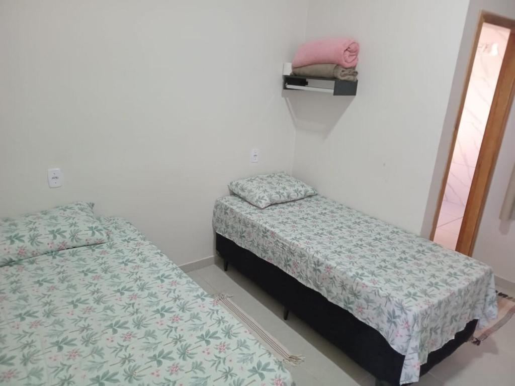 1 dormitorio con 2 camas y espejo. en Apartamento Confortável Novo com Ar condicionado, en Tangará da Serra