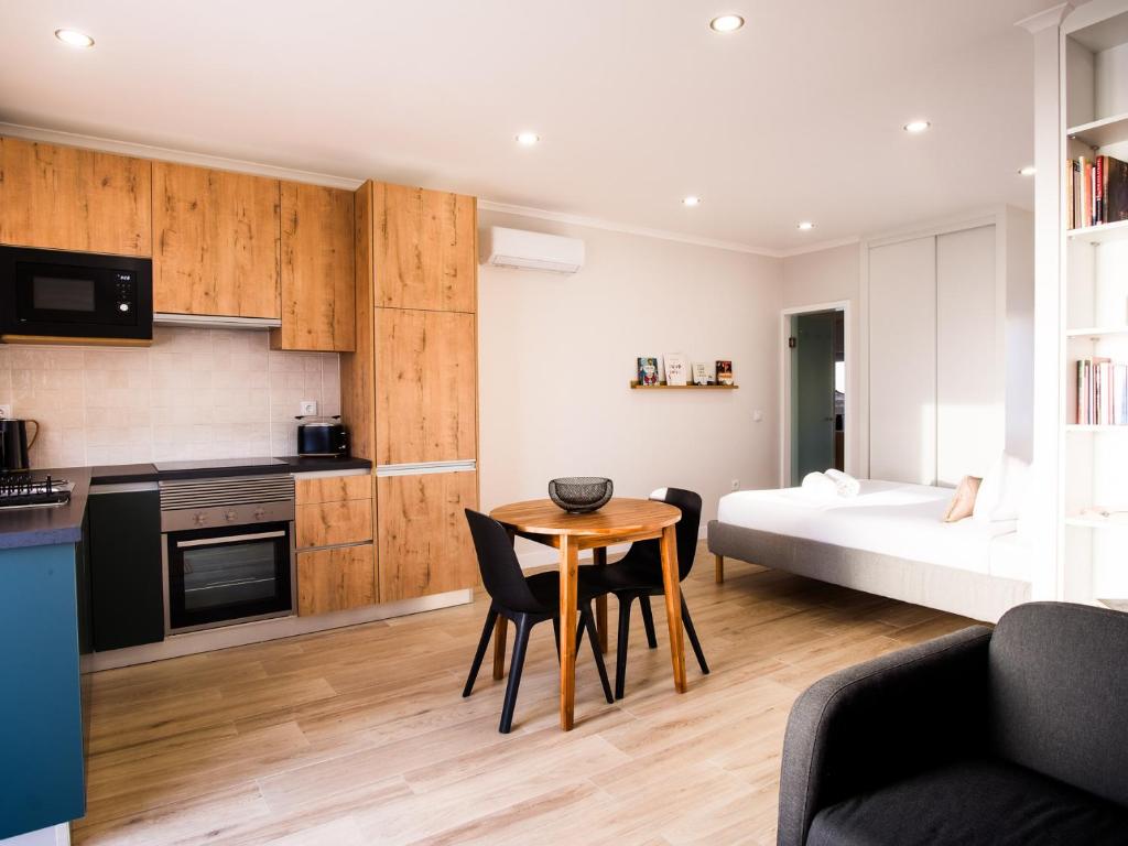 een keuken en een woonkamer met een tafel en een bed bij Casa Do Gato Das Sete Riscas in Óbidos