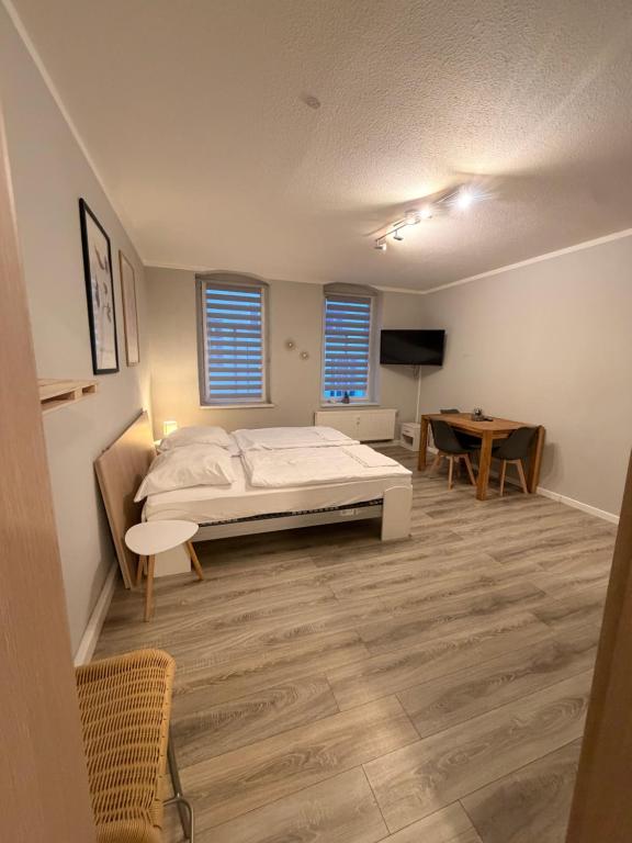 een slaapkamer met een bed en een tafel erin bij Laura Central Apartments in Gera