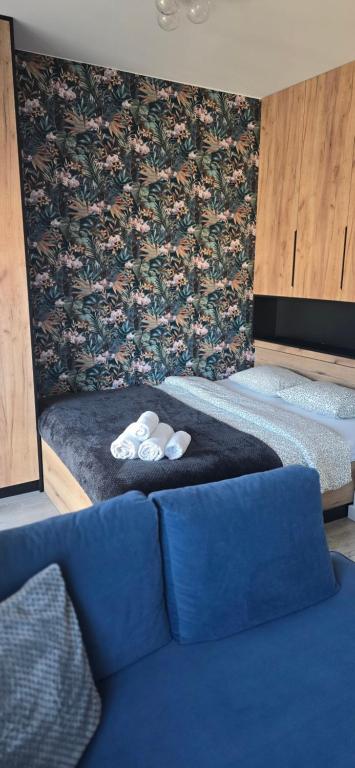 Zimmer mit 2 Betten und einem blauen Sofa in der Unterkunft Pomorska Apartment in Breslau
