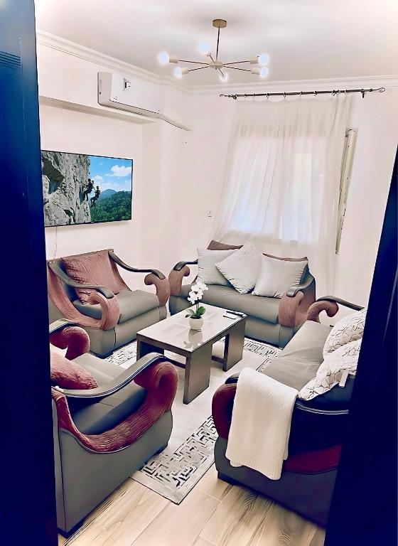a living room with couches and a table at Elegant Apartment at Sheikh Zayed Compound in Sheikh Zayed