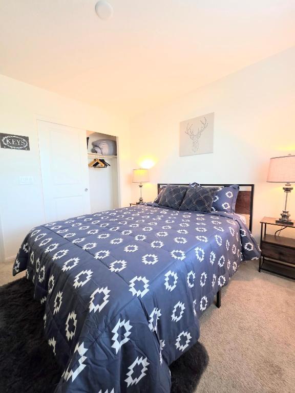 a bedroom with a bed with a blue and white comforter at 2-Bedroom Entire Guest Suite in North Las Vegas Mountain Views in Las Vegas