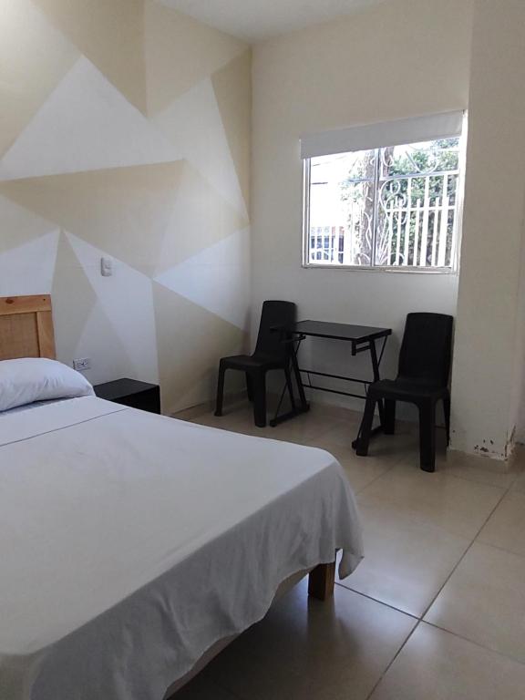 casa Marez في كارتاهينا دي اندياس: غرفة نوم بها سرير وكرسيين وطاولة