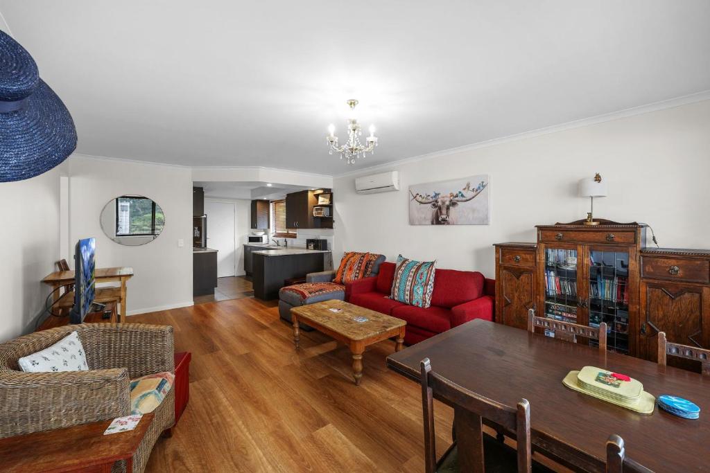 a living room with a red couch and a table at Beach Retreat in Warrnambool
