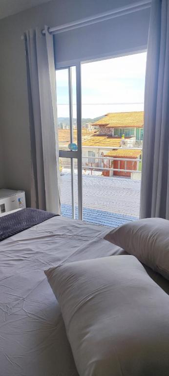 a bedroom with a bed and a large window at Suite Master Bella in São José