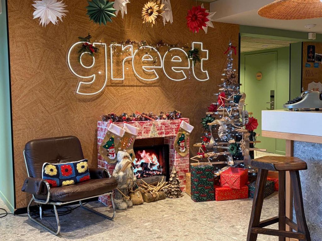 ein Weihnachtszimmer mit einem Kamin und einem Weihnachtsbaum in der Unterkunft Greet Hotel Colmar in Colmar