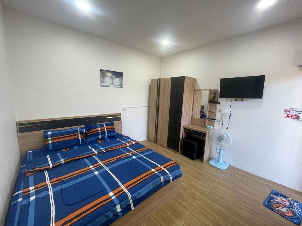 a bedroom with a bed and a flat screen tv at Manee House - บ้านมณี in Buriram