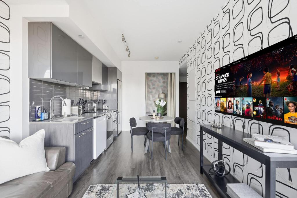 a kitchen and living room with a couch and a table at Bright Downtown Condo with City Views & Comfort in Toronto