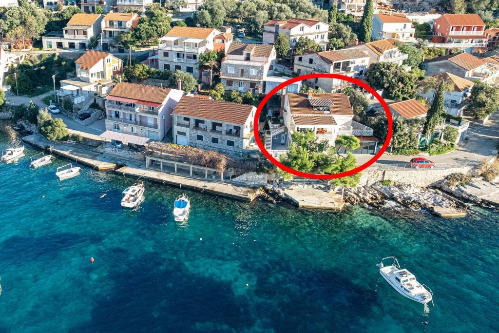 an aerial view of a house with a boat in the water at Apartments by the sea Brna, Korcula - 9275 in Brna