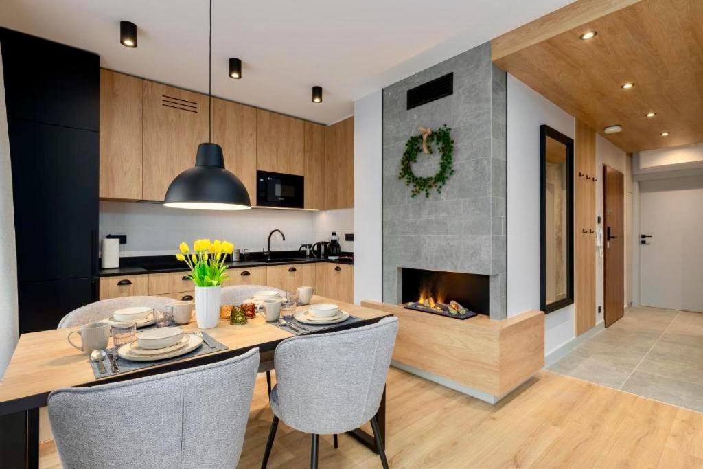 cocina con mesa de comedor y chimenea en REST4U APARTAMENTY z SAUNAMI, en Szczyrk