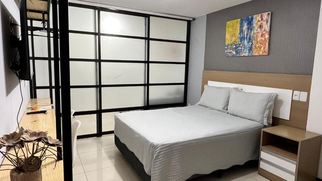 Praia dos Carneiros Flat Hotel Apto 302 Lindo e Completo في تامانداري: غرفة نوم بسرير أبيض ونافذة