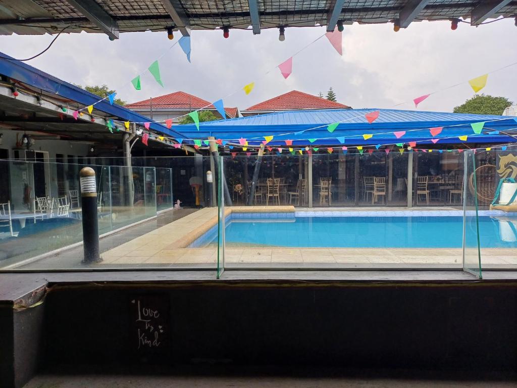 a pool with tables and chairs in a building at 8 dragon resort standard rooms in Silang