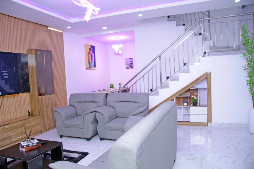 a living room with a couch and a staircase at 2 bedroom Apartment Lekki Ovation Terrace in Lekki
