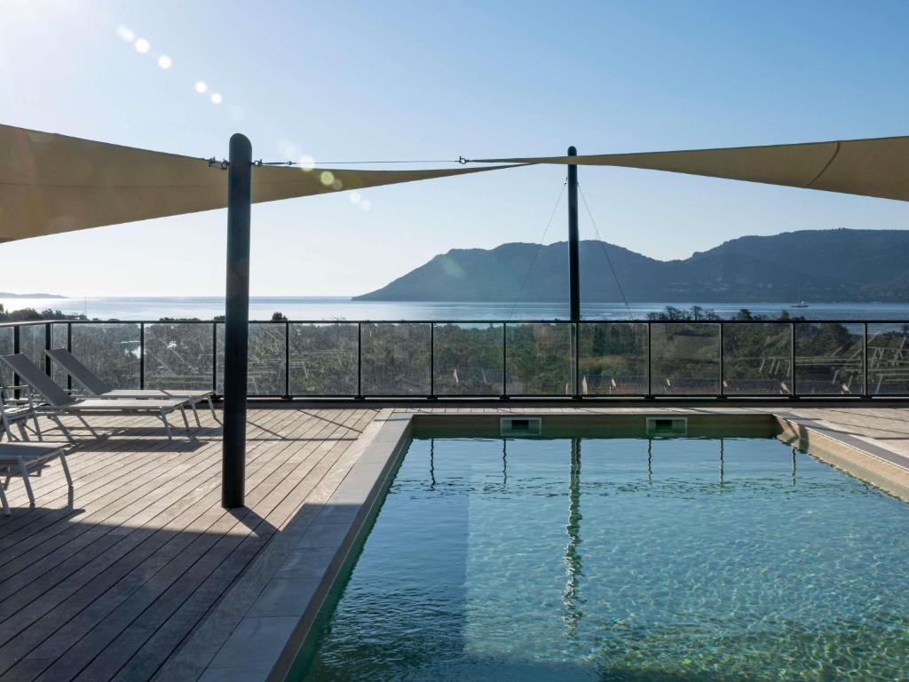 ein Swimmingpool mit Blick auf das Wasser in der Unterkunft ibis Styles Porto Vecchio in Porto-Vecchio