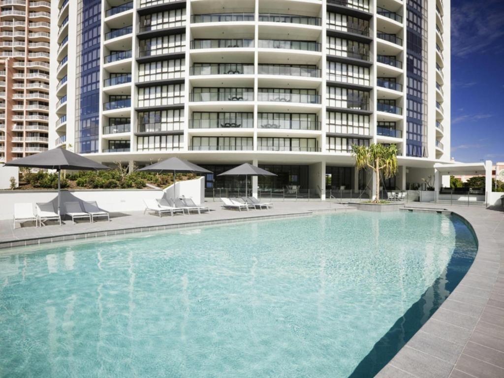 ein großer Pool vor einem großen Gebäude in der Unterkunft Mantra Sierra Grand in Gold Coast