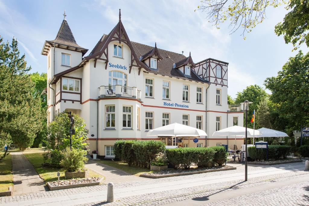 un gran edificio con sombrillas delante en Hotel-Pension Seeblick, en Kühlungsborn