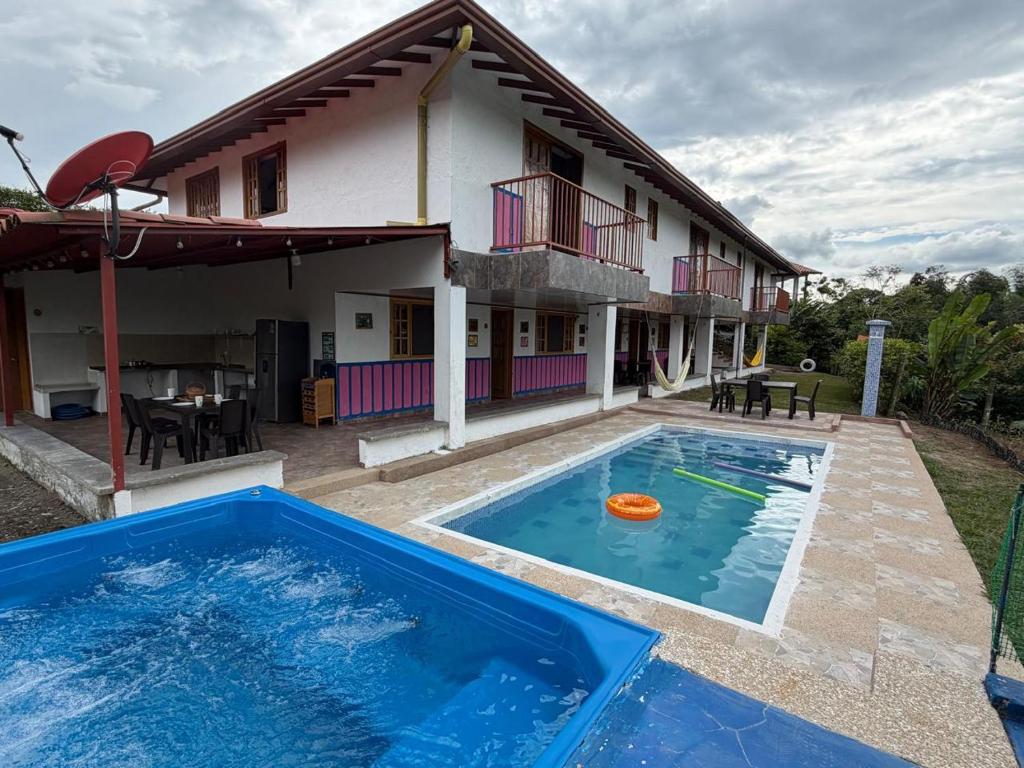 a house with a large swimming pool in front of it at Casa campestre Montenegro Quindio in Montenegro