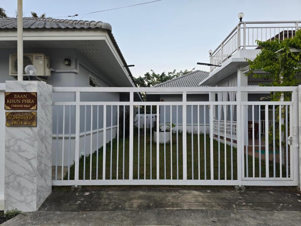 a white fence in front of a house at Baan Khun Pra Chiang Mai Near Chiang mai Airport in Chiang Mai