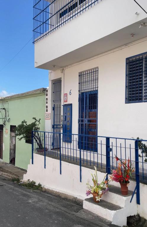 a white building with blue doors and a fence at Espacio Santa Bárbara, Zona Colonial in Santo Domingo