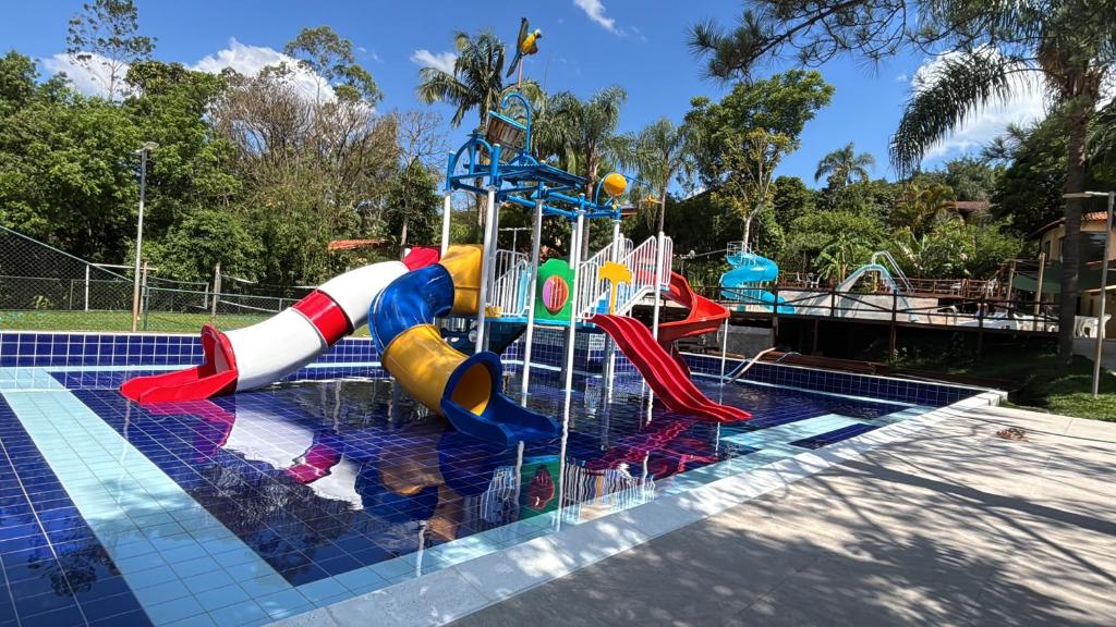 a pool with a water park with a water slide at Pousada Bezerra in Nazaré Paulista