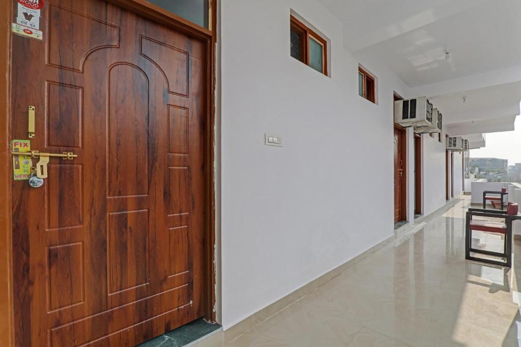 a large wooden door in a hallway with a floor at Hotel O Fine Stay Guest House in Bhauli