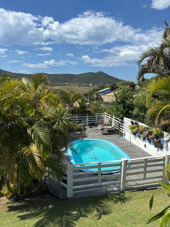a swimming pool with a fence around it at Pousada Sonho do Vale in Praia do Rosa