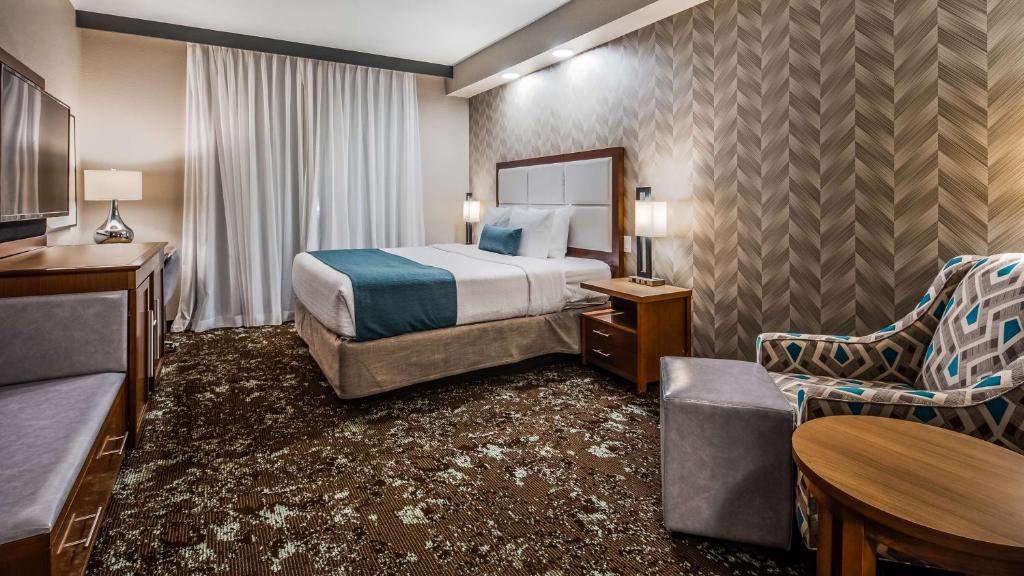 a hotel room with a bed and a chair at Best Western Premier Des Moines-Ankeny Hotel in Ankeny