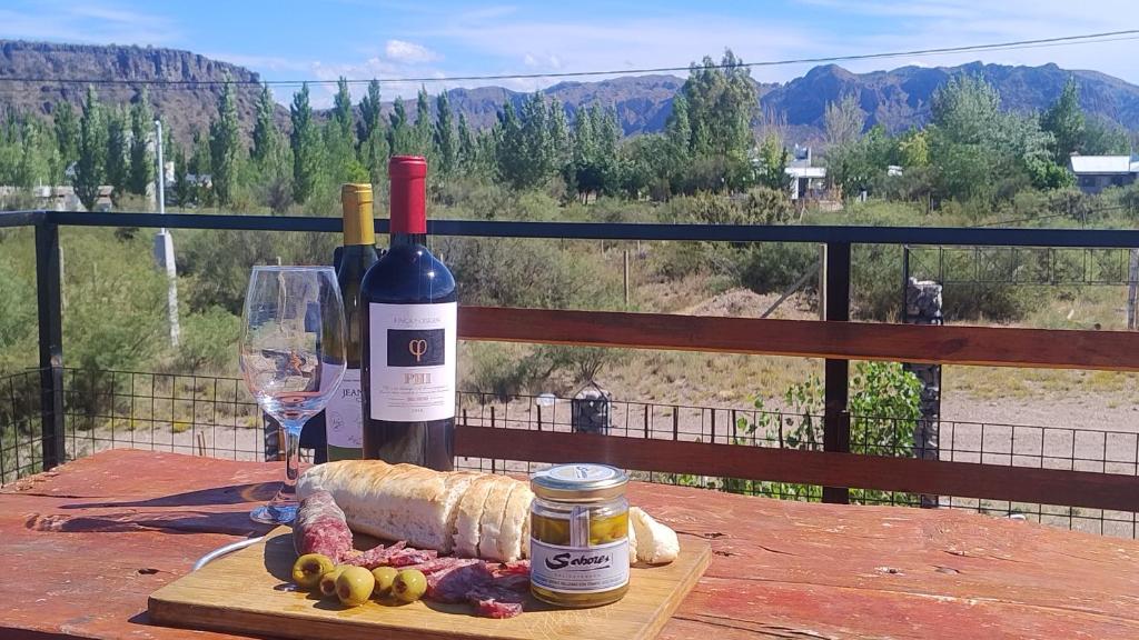 una mesa con dos botellas de vino y una copa en Preciosa Casa con Terraza al Valle Grande, San Rafael Mendoza de 1 a 5 Personas, en Valle Grande