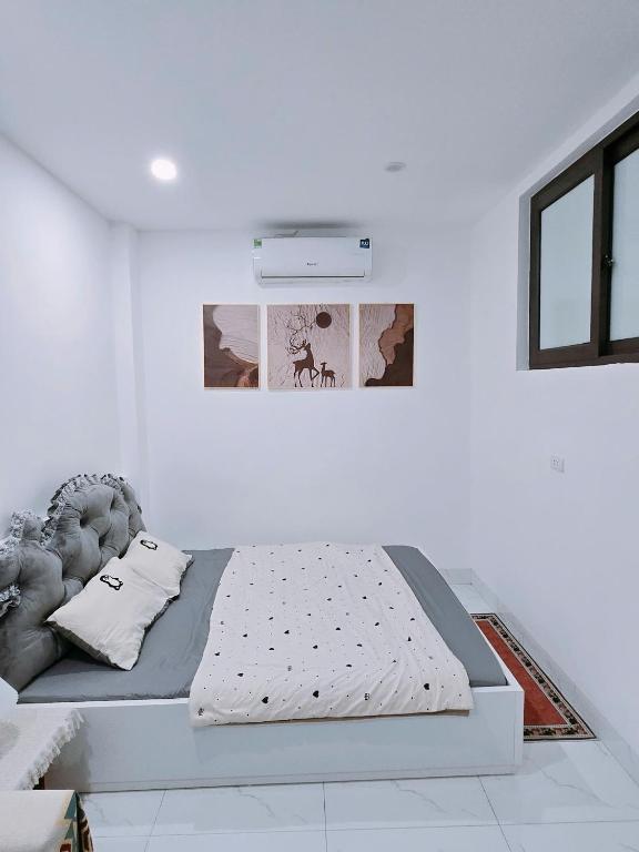a white bedroom with a bed in a room at Hear Homestay Tây Hồ in Hanoi